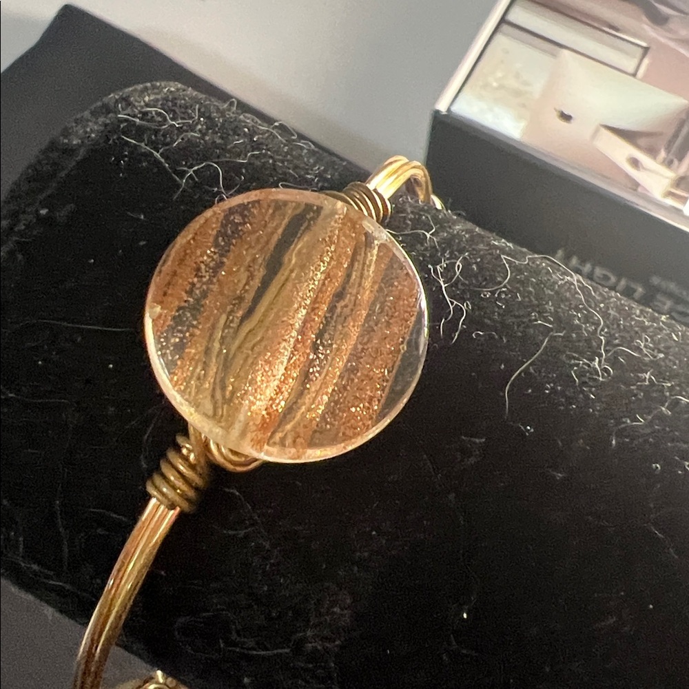 Bourbon and Boweties bangle features 3 Gold flecked beads and a signature logo